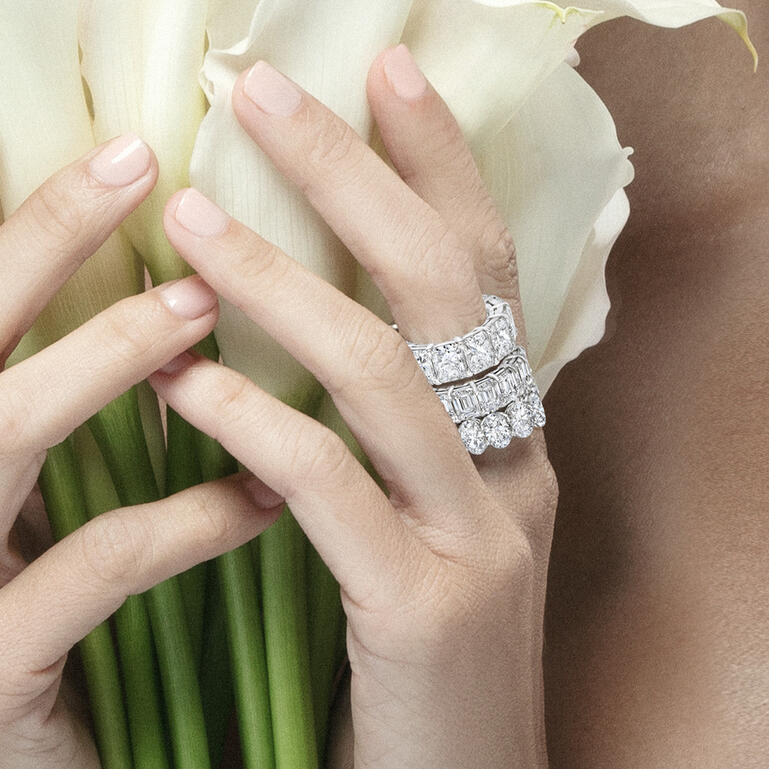 Hands holding flowers while wearing diamond bands