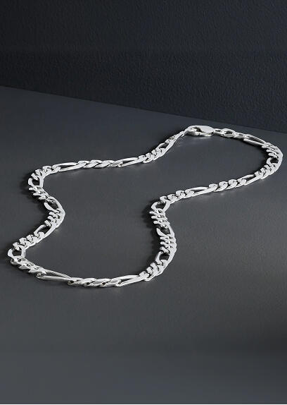 A white gold necklace rests on a gray surface.