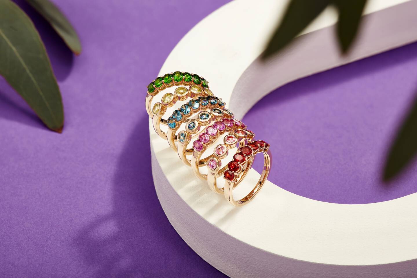 Colorful gemstone rings with a white and purple background