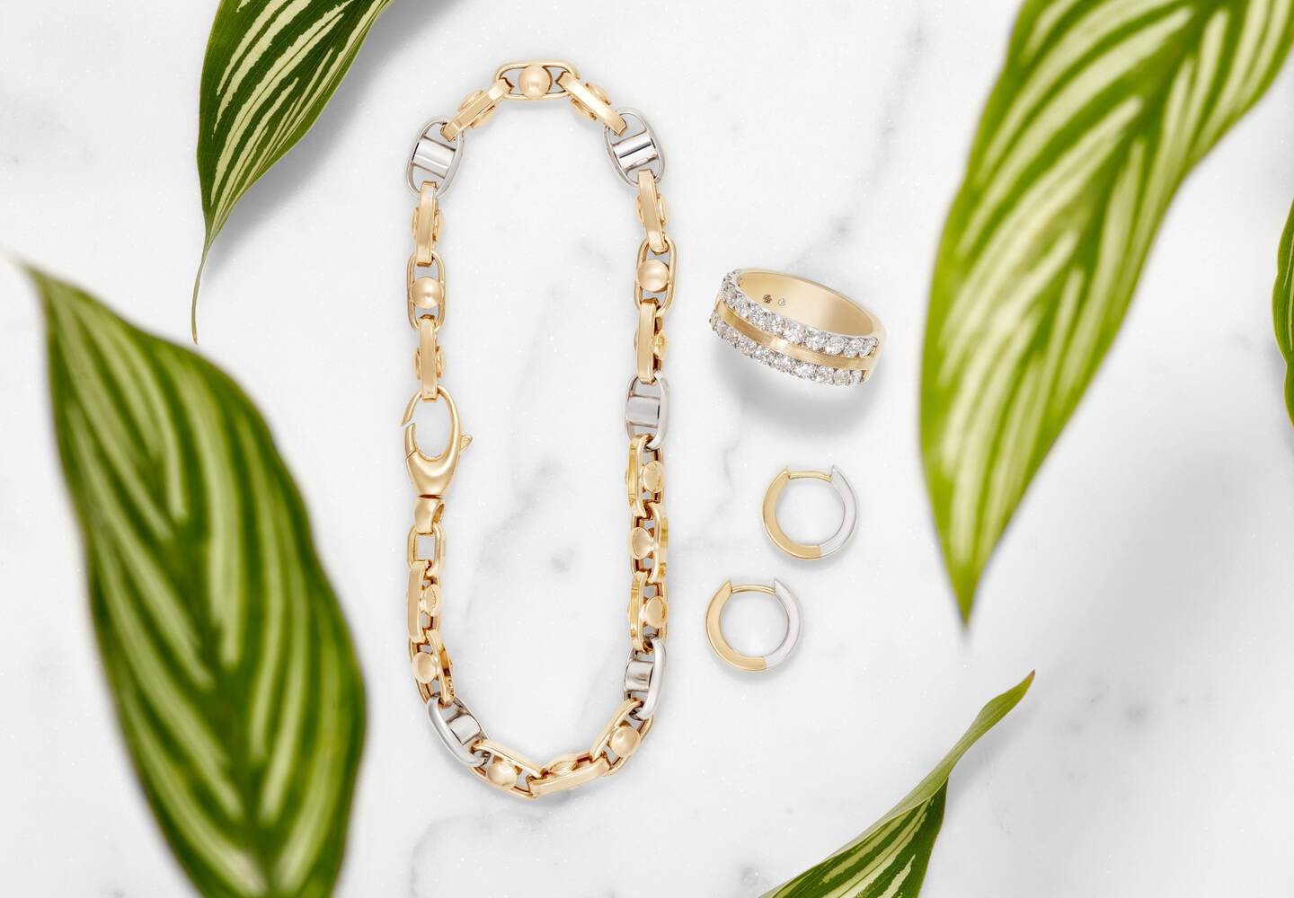 A bracelet, hoop earrings and a ring made with white and yellow gold.