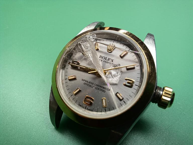 Luxury watch with a broken crystal.