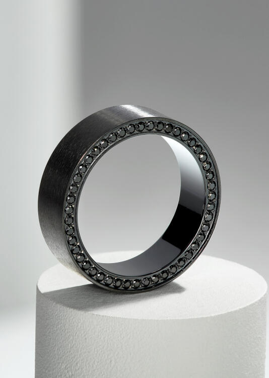 A wedding band standing up on edge with round accent diamonds.