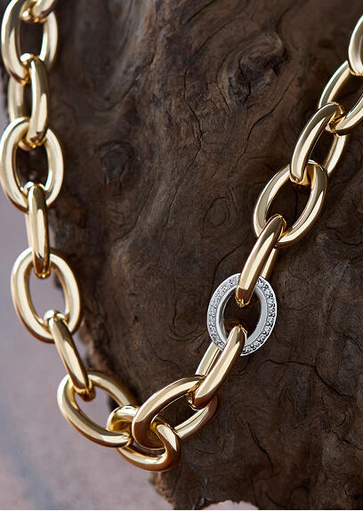 A bold yellow gold necklace with a diamond encrusted white gold link.
