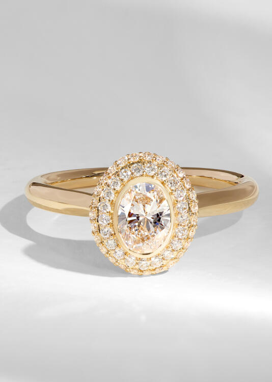 An oval diamond double halo ring in yellow gold