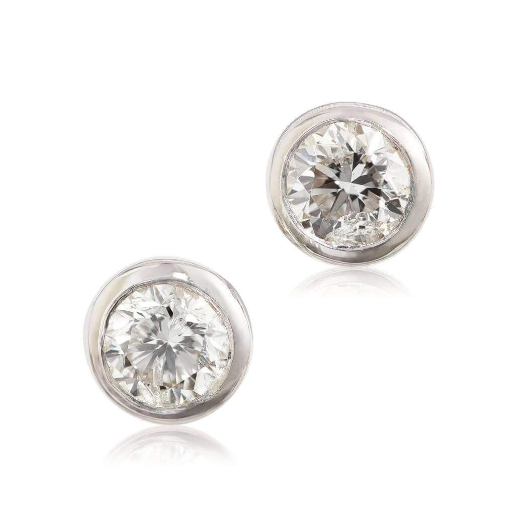 Bezel-set diamond studs against a white background