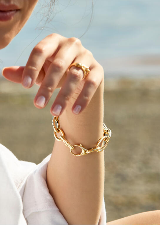 A yellow gold bracelet on a woman&rsquo;s wrist