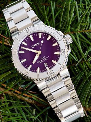 Gold studs rest atop a gift box adorned with a white ribbon. 