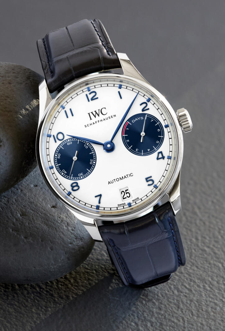 An IWC chronograph watch with blue hands on a blue leather strap.