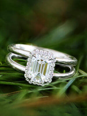 Diamond engagement ring set in 14k white gold shines on a bed of evergreen needles.
