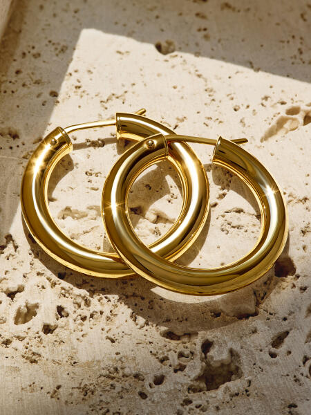 Classic yellow gold hoop earrings reflect the light beautifully.