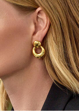 Side profile of a woman wearing a yellow gold open circle earring.