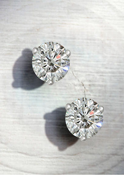 A pair of round diamond stud earrings in white gold.