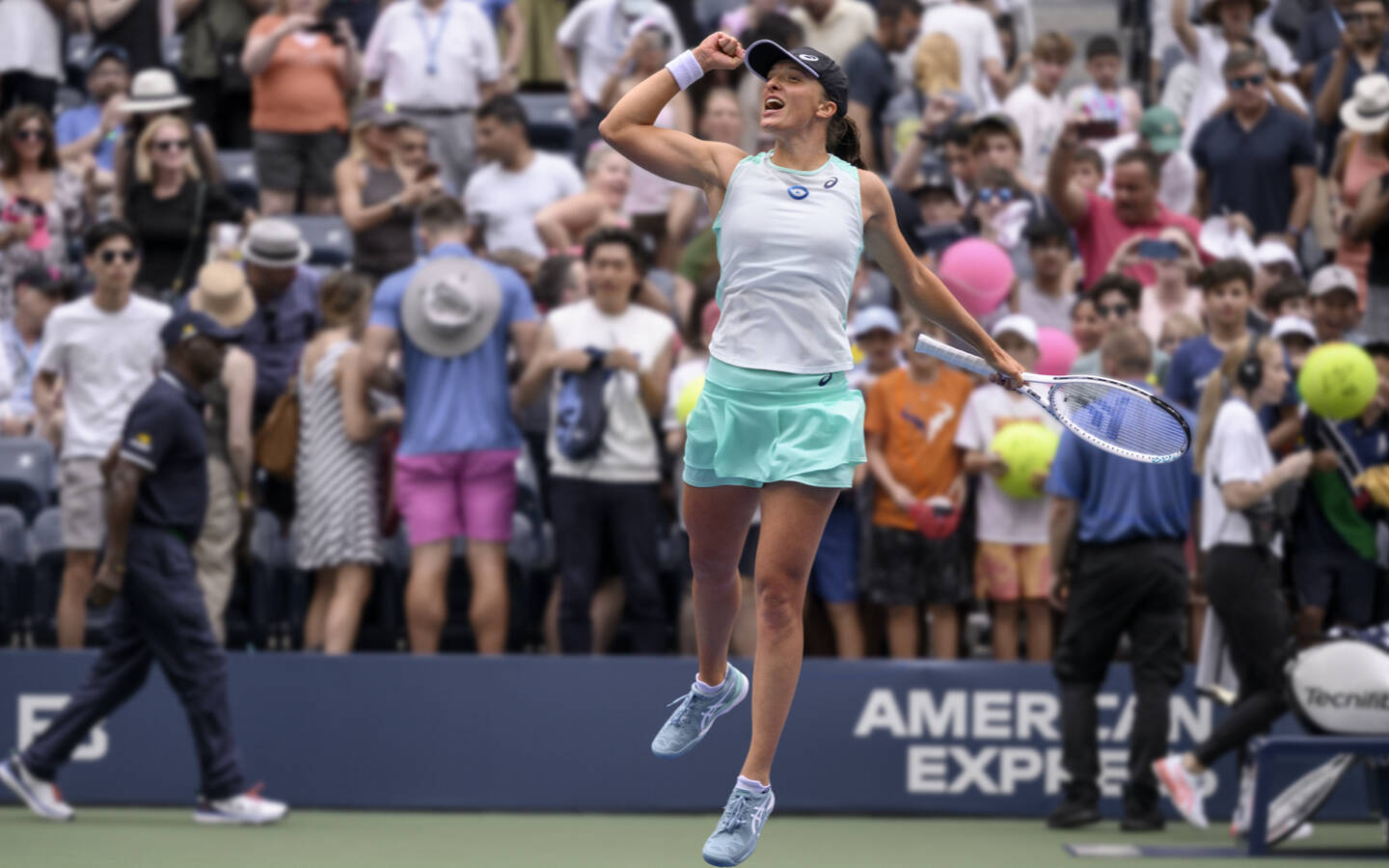 Tennis star goes airborne returning a volley during a US Open tennis match.