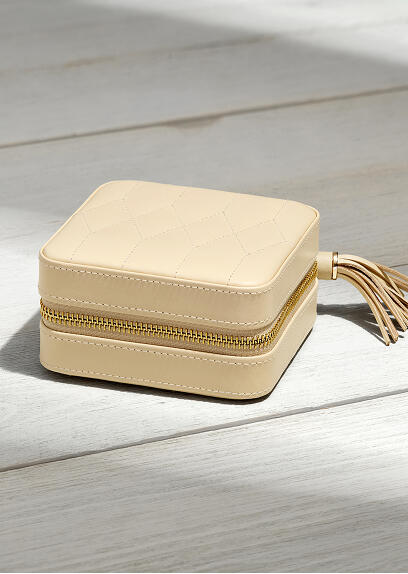 Small cream-colored jewelry box for traveling.