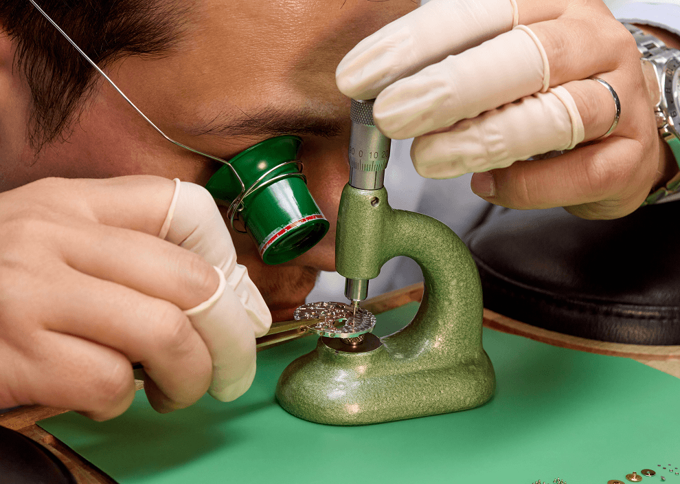 Closeup of a watch technician inspecting interior mechanics of watch