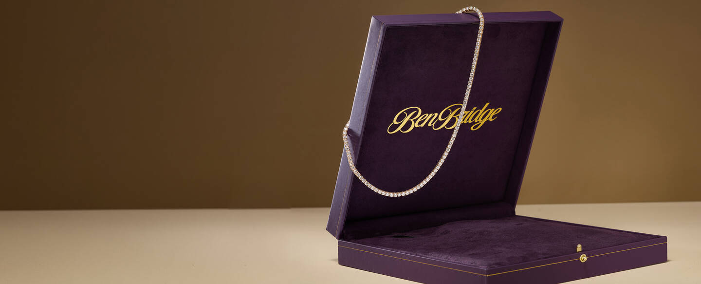 Diamond tennis necklace draped on purple jewelry box that features the Ben Bridge logo