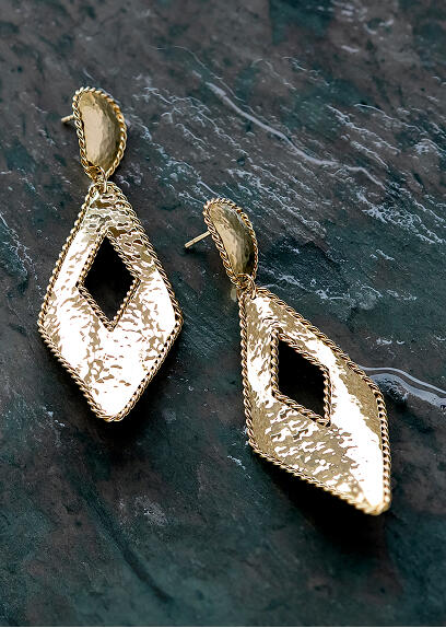 Yellow gold kite shaped earrings with an open center glow against a dark slate background