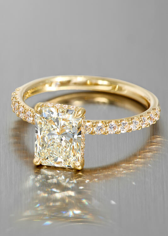 A radiant cut diamond engagement ring in yellow gold.