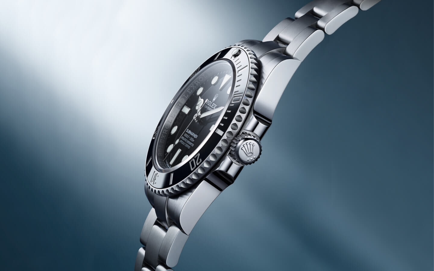 Side view of the Rolex Oyster Perpetual Submariner against a greyish blue background streaked with white light
