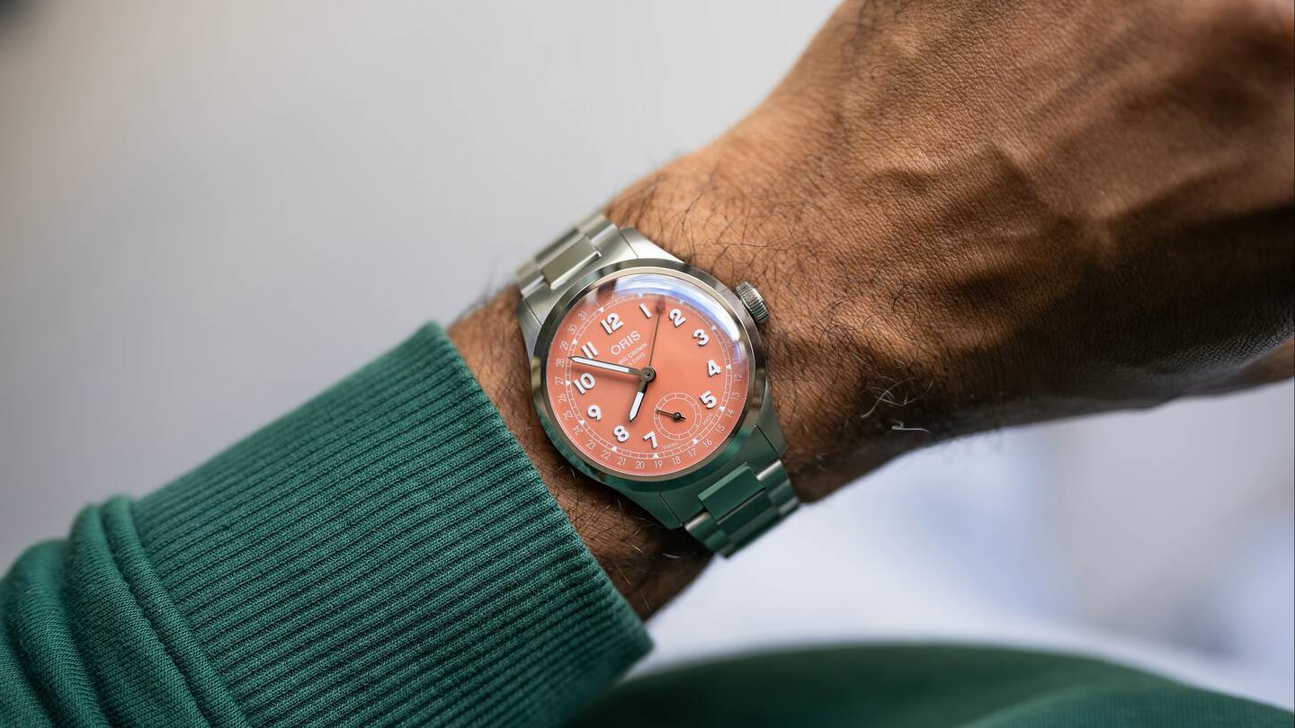 Oris watch with pastel dial on man's wrist. 