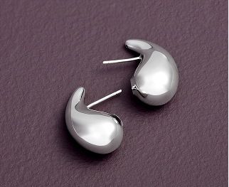 A pair of sterling silver Toscano earrings is shown on a textured purple background.