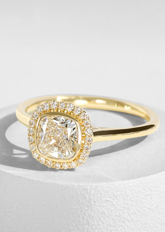 A classic halo diamond engagement ring in yellow gold.