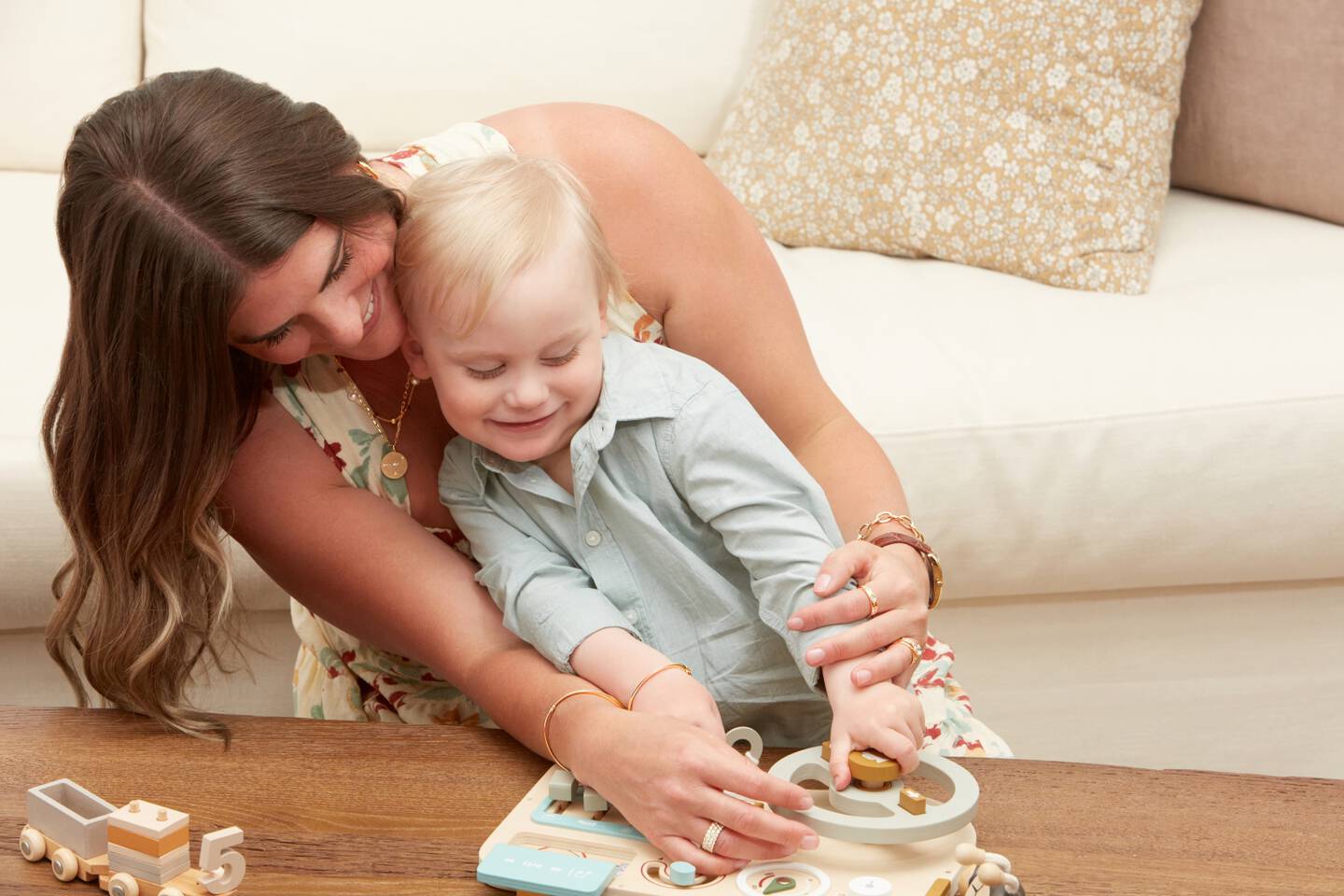 Mom wearing nice jewelry and watch with her arms around her baby. 