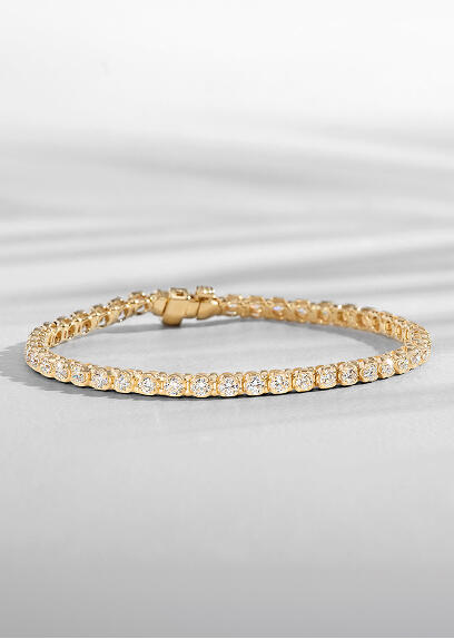 A classic tennis bracelet in yellow gold sparkles with natural round diamonds.