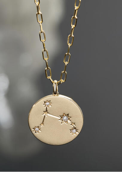 A yellow gold and diamond pendant set in a zodiac sign.