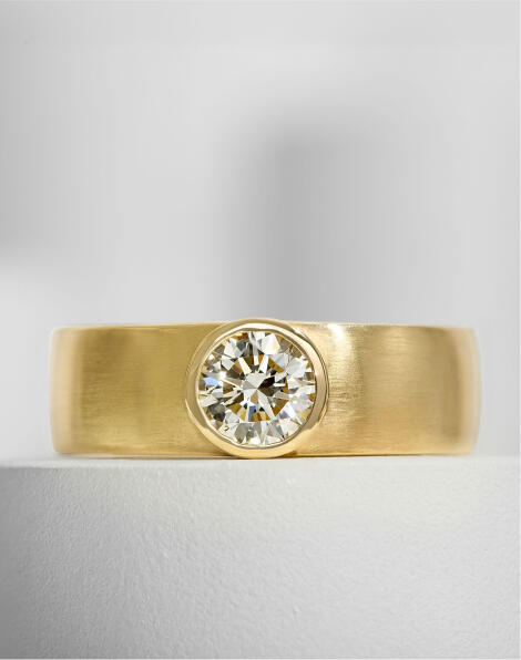 A bold men&rsquo;s wedding band in yellow gold featuring a solitaire round diamond. 