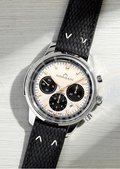 A chronograph watch with a leather strap and cream-colored dial.