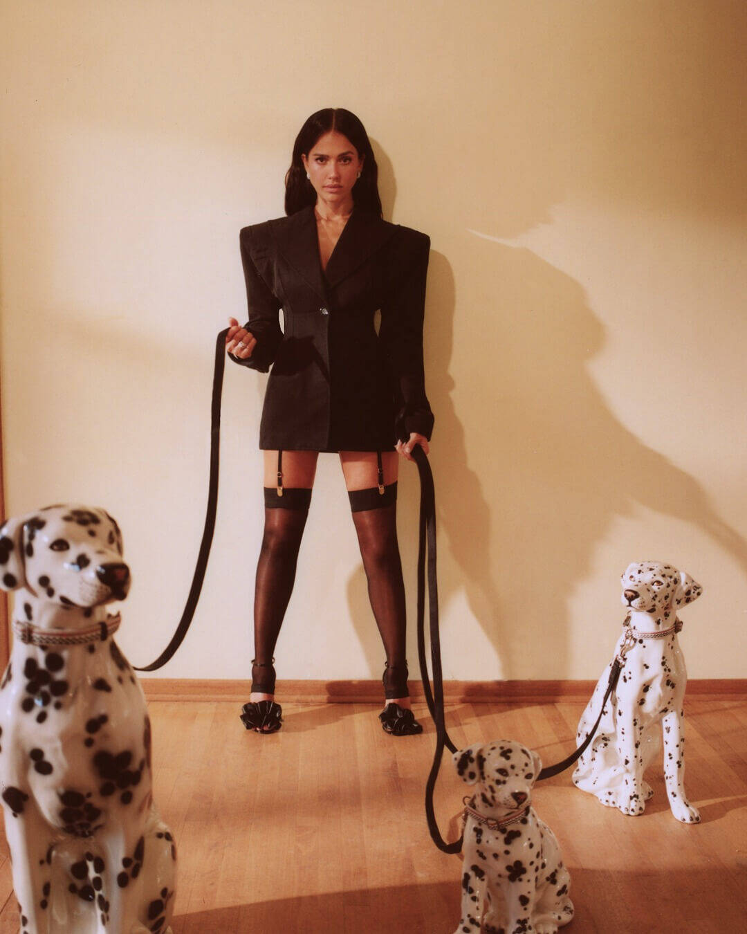 Jessica Alba wearing Ben Bridge earrings and rings with a black Dolche & Gabbana jacket, matching stockings, garter belt and shoes. 