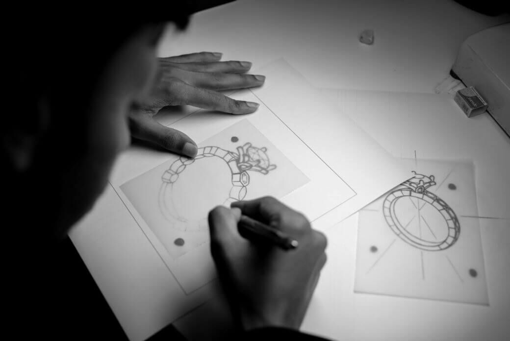 A person sketches out out an engagement ring design concept by hand