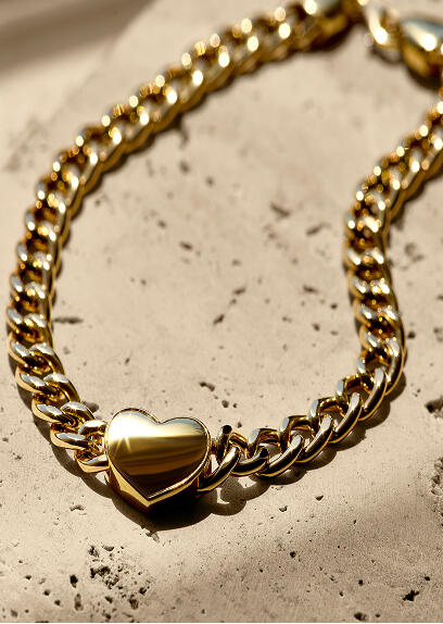 A bracelet crafted with yellow gold links and a gold heart charm.