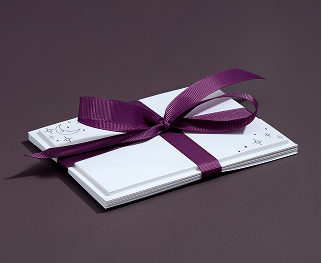 A stationary set held together with a purple ribbon bow