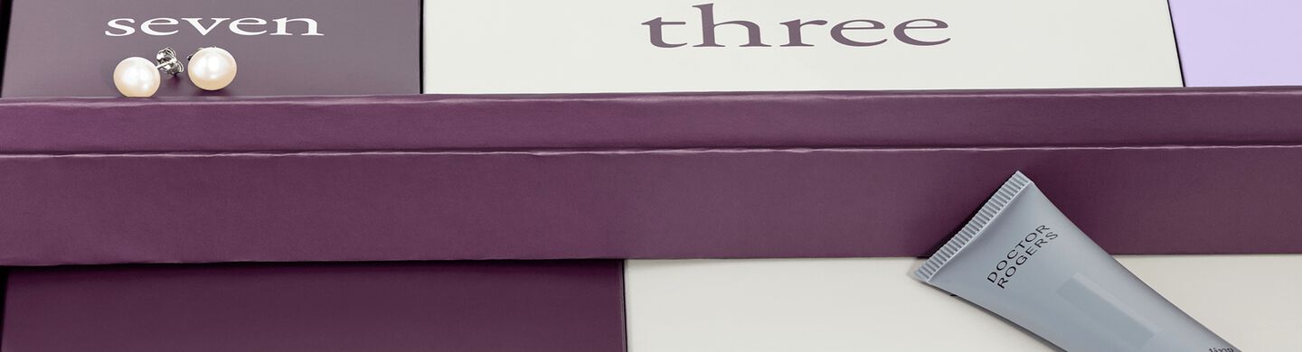 A partial view of the Ben Bridge advent calendar with a pair of pearl studs resting atop the box for day seven.