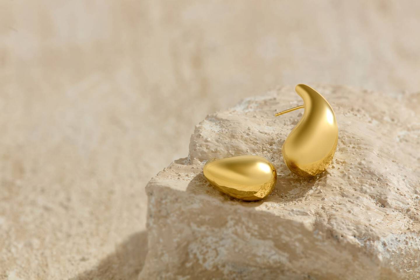 A yellow gold paperclip chain is draped across a woman's fingers