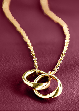 Yellow gold necklace with double gold interlocking hoops against a purple background 