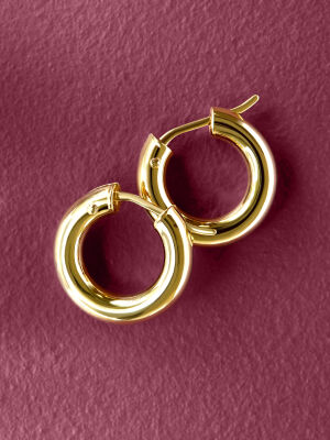 Two yellow gold hoops on a purple background.