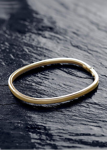 A yellow gold bangle with a hinge clasp.