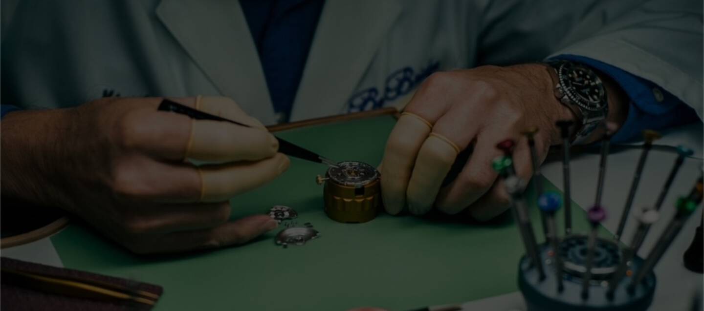 Watch repair expert is working on fine jewelry with a pair of magnifying goggles.
