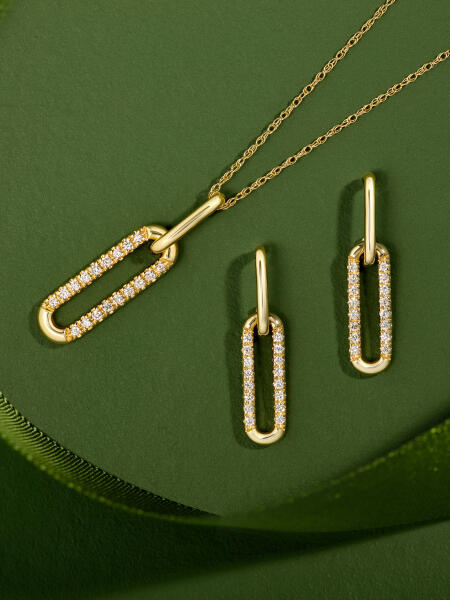 Oval shaped earrings and pendant with round diamond accents, in yellow gold.