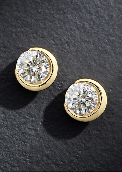 Round diamond stud earrings with a half-moon bezel setting of yellow gold.