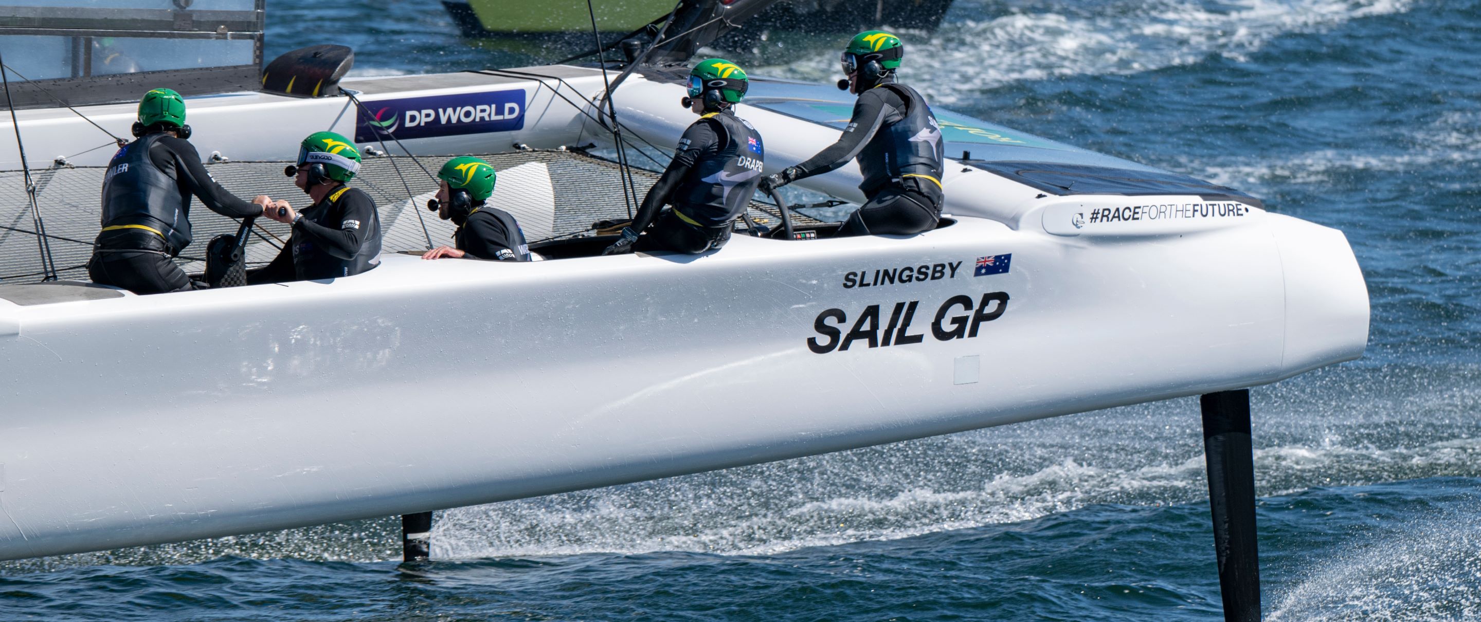 The crew of a catamaran works the sails during a SailGP race. 
